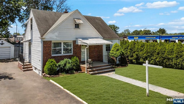 837 Keep St, Linden, NJ 07036 - bungalow with a front yard, brick siding, a storage unit, driveway, and roof with shingles