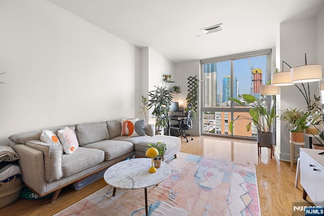 201 Marin Blvd Unit 1209, Jersey City, NJ 07302 - living area featuring expansive windows, light wood-style flooring, and a desk