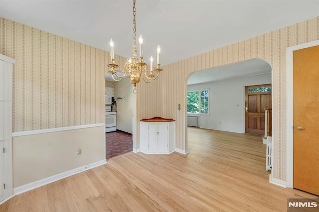 33 Ravine Dr, Hawthorne, NJ 07506 - unfurnished dining area with arched walkways, wallpapered walls, wood finished floors, a chandelier, and radiator