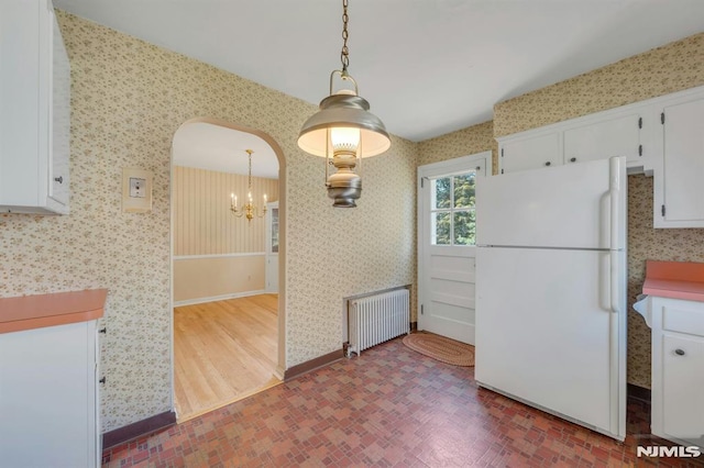 33 Ravine Dr, Hawthorne, NJ 07506 - kitchen with freestanding refrigerator, radiator, wallpapered walls, a chandelier, and white cabinetry