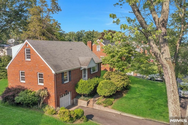 33 Ravine Dr, Hawthorne, NJ 07506 - view of front of house with an attached garage, brick siding, a front lawn, a chimney, and driveway