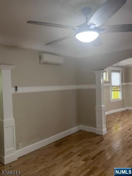 34 Voorhees St, Newark, NJ 07108 - below grade area with an AC wall unit, a ceiling fan, and wood finished floors
