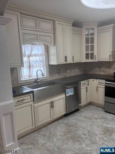 34 Voorhees St, Newark, NJ 07108 - kitchen featuring stainless steel appliances, tasteful backsplash, dark countertops, and glass insert cabinets