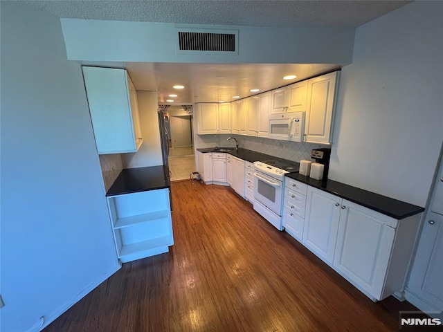 245 Prospect Ave Unit 5A, Hackensack, NJ 07601 - kitchen with white appliances, white cabinets, dark wood-style floors, dark countertops, and backsplash