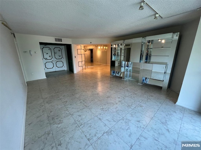 245 Prospect Ave Unit 5A, Hackensack, NJ 07601 - unfurnished living room featuring a textured ceiling and a chandelier
