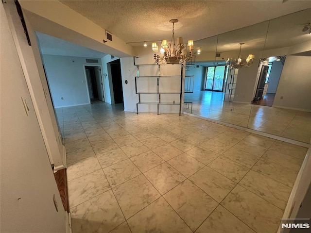 245 Prospect Ave Unit 5A, Hackensack, NJ 07601 - empty room featuring a chandelier, a textured ceiling, and light tile patterned floors
