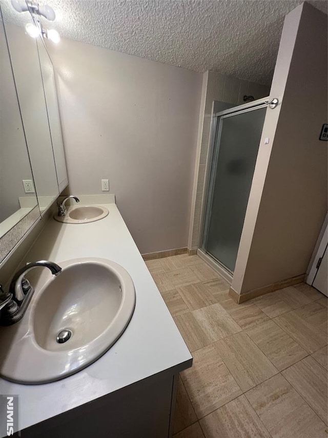 245 Prospect Ave Unit 5A, Hackensack, NJ 07601 - bathroom with a textured ceiling, a stall shower, double vanity, and tile patterned floors