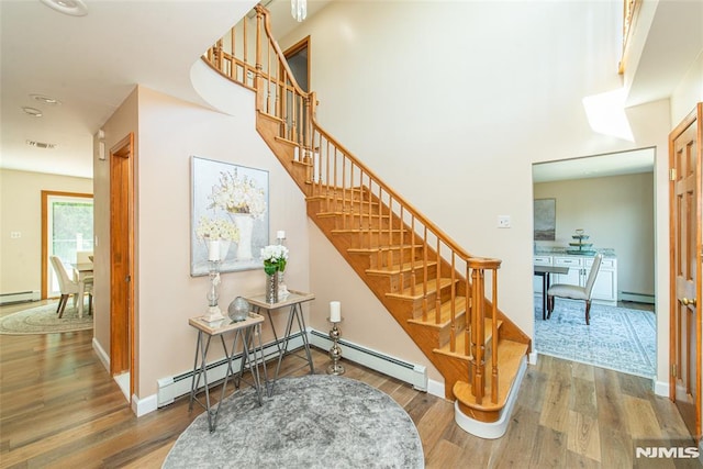 44 Columbus Ave, Totowa, NJ 07512 - stairs featuring wood finished floors, a baseboard heating unit, recessed lighting, a baseboard radiator, and baseboard heating