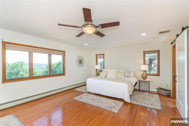 44 Columbus Ave, Totowa, NJ 07512 - bedroom with a barn door, baseboard heating, wood finished floors, recessed lighting, and ceiling fan