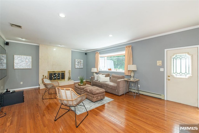 44 Columbus Ave, Totowa, NJ 07512 - living area with a baseboard heating unit, ornamental molding, wood finished floors, recessed lighting, and a tiled fireplace