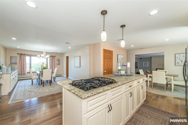 44 Columbus Ave, Totowa, NJ 07512 - kitchen featuring black gas stovetop, dark wood-style flooring, light stone countertops, a center island, and a chandelier