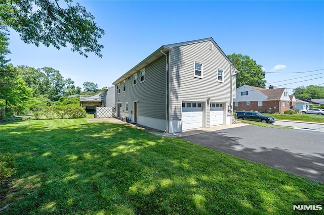 87 Larkspur Ln, Clifton, NJ 07013 - view of home's exterior featuring asphalt driveway, a garage, and a lawn