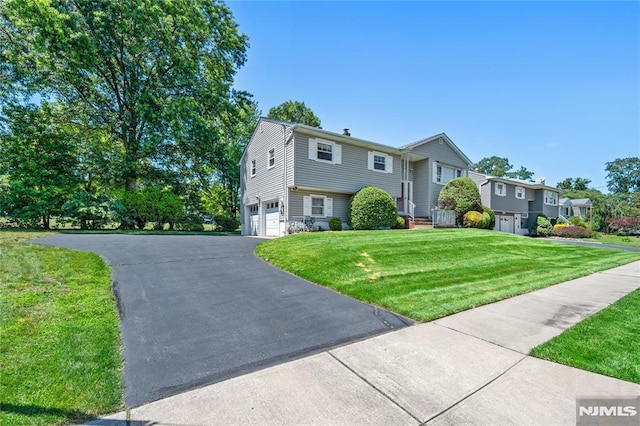 87 Larkspur Ln, Clifton, NJ 07013 - bi-level home featuring an attached garage, asphalt driveway, and a front lawn