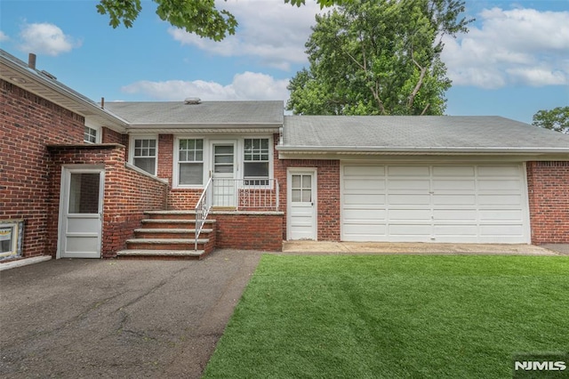 12 Moore Pl, Belleville, NJ 07109 - view of front of house with brick siding, asphalt driveway, a front yard, a shingled roof, and a garage