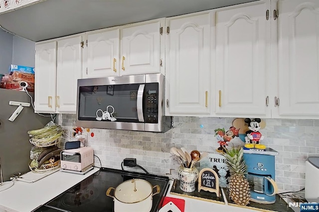 299 7th Ave, Newark, NJ 07107 - kitchen featuring stainless steel microwave, white cabinetry, and tasteful backsplash