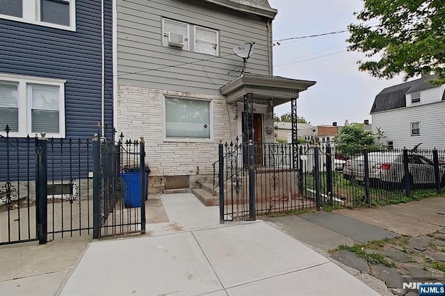 299 7th Ave, Newark, NJ 07107 - view of front facade with stone siding, a fenced front yard, and a gate
