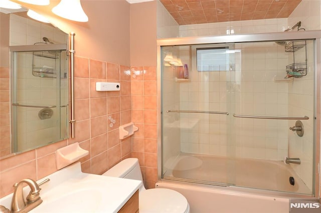39 Mozart St, East Rutherford, NJ 07073 - bathroom featuring tile walls, bath / shower combo with glass door, and vanity