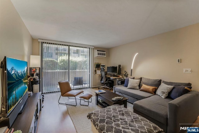 462 Liberty St Unit 109, Little Ferry, NJ 07643 - living room with wood finished floors, expansive windows, a wall mounted air conditioner, and a desk