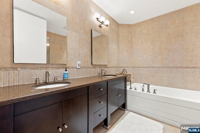 100 Carlyle Dr Unit 12K-S, Cliffside Park, NJ 07010 - full bathroom featuring tile walls, double vanity, a garden tub, backsplash, and tile patterned flooring