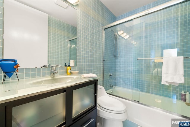 100 Carlyle Dr Unit 12K-S, Cliffside Park, NJ 07010 - bathroom featuring tile walls, vanity, enclosed tub / shower combo, and tasteful backsplash