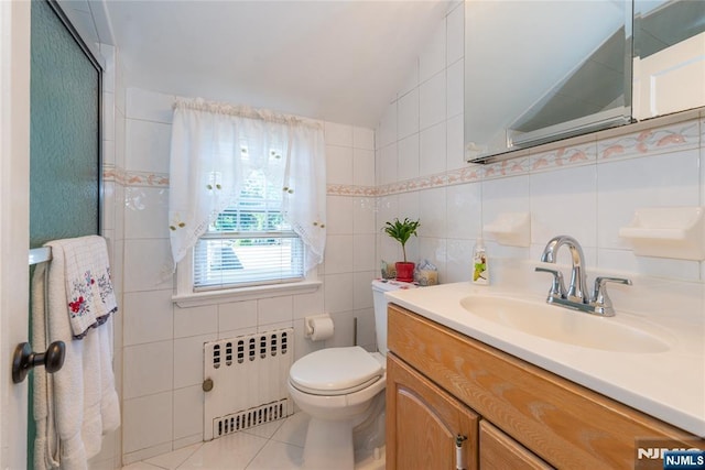 55 Rowland Ave, Hackensack, NJ 07601 - bathroom with radiator heating unit, vaulted ceiling, tile walls, vanity, and tile patterned floors