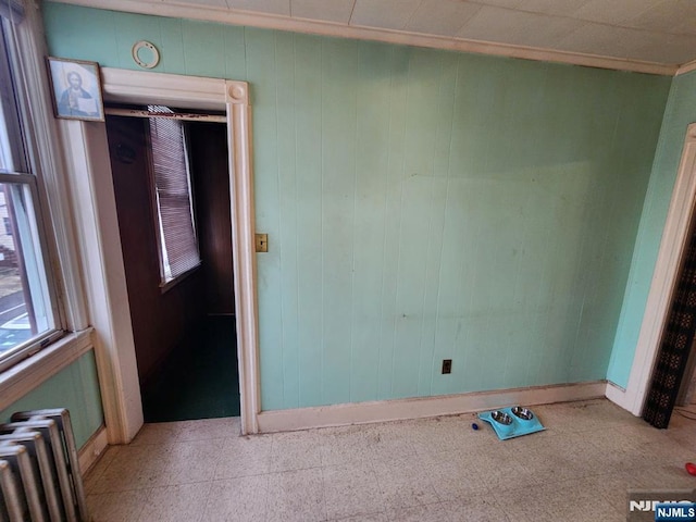 4311 Cottage Ave, North Bergen, NJ 07047 - spare room with radiator heating unit, tile patterned floors, and wooden walls