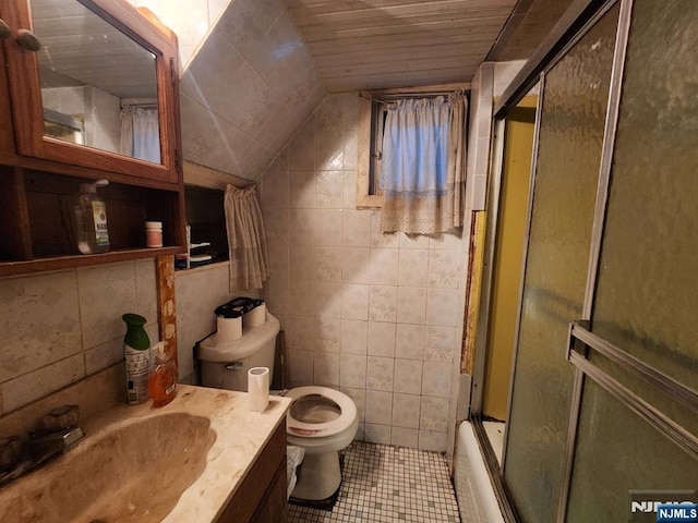 4311 Cottage Ave, North Bergen, NJ 07047 - full bath featuring vanity, tile patterned floors, vaulted ceiling, shower / bath combination with glass door, and tile walls