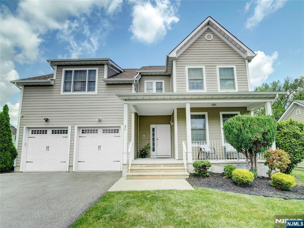 35 College Ave, East Orange, NJ 07017 - view of front facade featuring asphalt driveway, a porch, and a garage