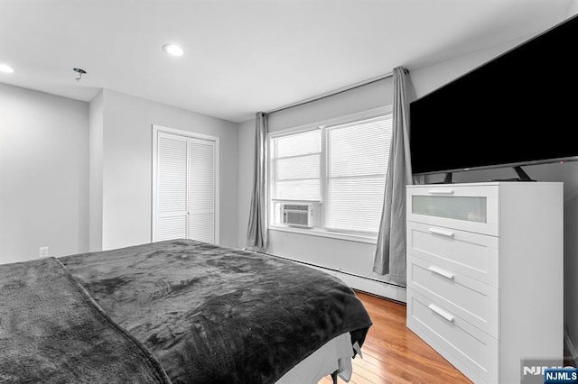 203 Central Ave, Bogota, NJ 07603 - bedroom featuring recessed lighting, cooling unit, light wood-style floors, a closet, and baseboard heating