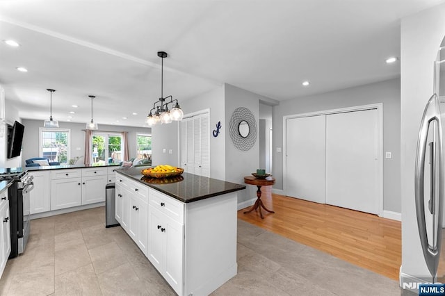 203 Central Ave, Bogota, NJ 07603 - kitchen featuring gas range, recessed lighting, white cabinetry, a kitchen island, and hanging light fixtures
