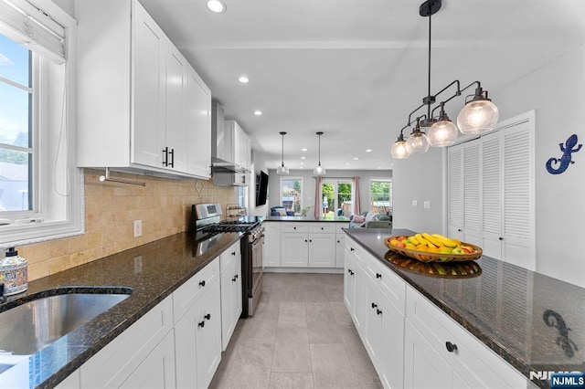203 Central Ave, Bogota, NJ 07603 - kitchen featuring gas stove, wall chimney range hood, recessed lighting, white cabinets, and tasteful backsplash