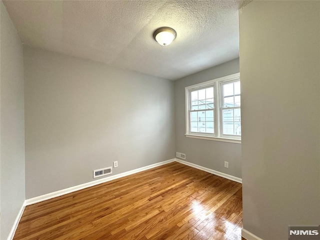 9 Westervelt Pl, Irvington, NJ 07111 - empty room with wood finished floors and a textured ceiling