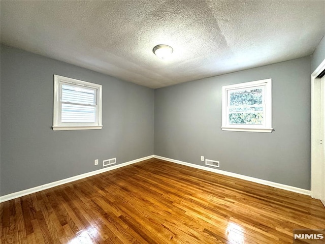 9 Westervelt Pl, Irvington, NJ 07111 - empty room with wood finished floors and a textured ceiling