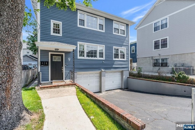 9 Westervelt Pl, Irvington, NJ 07111 - view of front of home with an attached garage and asphalt driveway