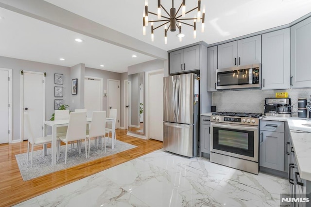 9 Westervelt Pl, Irvington, NJ 07111 - kitchen with stainless steel appliances, gray cabinetry, a chandelier, decorative backsplash, and recessed lighting