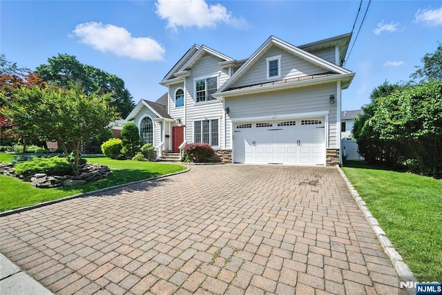 6 Highland Ave, Demarest, NJ 07627 - view of front of property featuring stone siding, decorative driveway, a front yard, a standing seam roof, and an attached garage