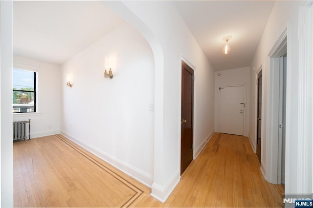 1100 83rd St Unit 301, North Bergen, NJ 07047 - hall with radiator, light wood finished floors, and arched walkways