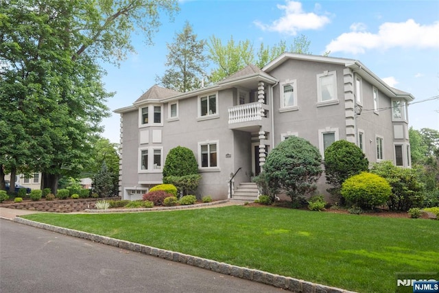 216 8th St, Cresskill, NJ 07626 - view of front of property featuring stucco siding, a front lawn, and a balcony