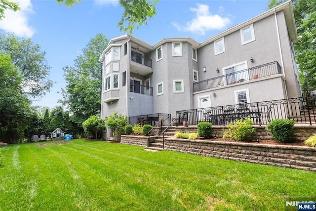 216 8th St, Cresskill, NJ 07626 - rear view of house with stucco siding and a lawn