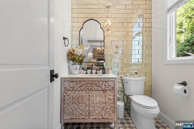 216 8th St, Cresskill, NJ 07626 - bathroom featuring vanity, plenty of natural light, a chandelier, and tile patterned floors