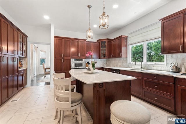 216 8th St, Cresskill, NJ 07626 - kitchen featuring light countertops, hanging light fixtures, tasteful backsplash, a kitchen bar, and a kitchen island