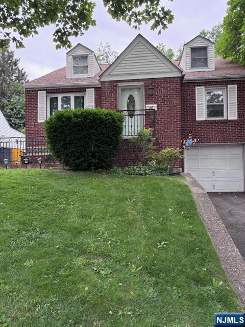 46-48 Brook Ave, Passaic, NJ 07055 - view of front of home with brick siding, asphalt driveway, a front yard, and an attached garage