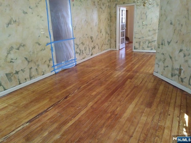 17 48th St, Weehawken, NJ 07086 - unfurnished room featuring hardwood / wood-style floors, a chandelier, and wallpapered walls