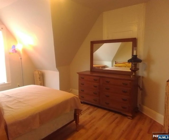 17 48th St, Weehawken, NJ 07086 - bedroom with radiator, light wood finished floors, and lofted ceiling