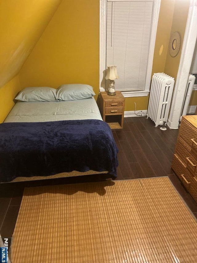17 48th St, Weehawken, NJ 07086 - bedroom with radiator, wood finished floors, and vaulted ceiling