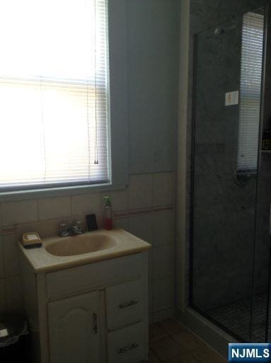 17 48th St, Weehawken, NJ 07086 - full bath featuring a shower stall, vanity, tile patterned flooring, and tile walls