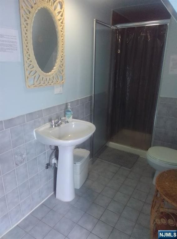 17 48th St, Weehawken, NJ 07086 - bathroom with tile walls, tile patterned floors, a stall shower, and wainscoting