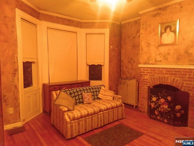 17 48th St, Weehawken, NJ 07086 - living area featuring radiator, wood finished floors, ornamental molding, a fireplace, and wallpapered walls
