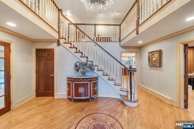 307 Freemans Ln, Franklin Lakes, NJ 07417 - staircase with a chandelier, wood finished floors, a high ceiling, and ornamental molding