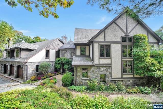307 Freemans Ln, Franklin Lakes, NJ 07417 - tudor-style house with stone siding, stucco siding, and a garage